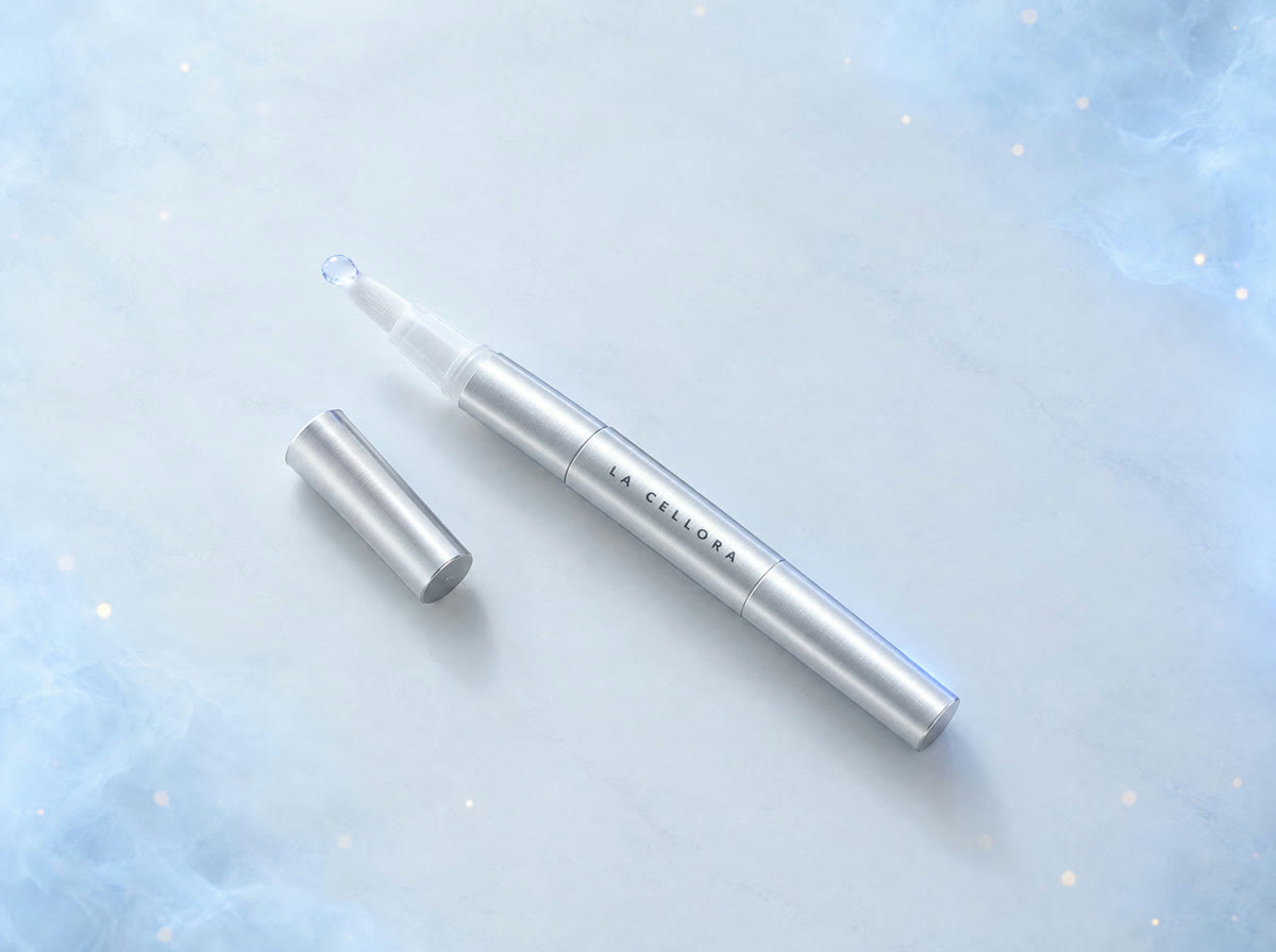 A silver La Cellora whitening pen with a drop of gel on its brush tip